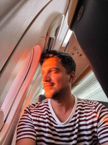 imgi_21_young-man-looking-out-of-the-airplane-window-during-flight-at-sunset imgi_21_young-man-looking-out-of-the-airplane-window-during-flight-at-sunset